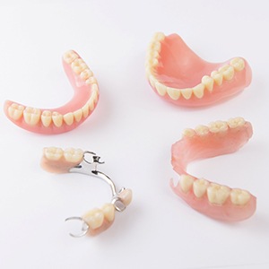 Full and partial dentures arranged against neutral background
