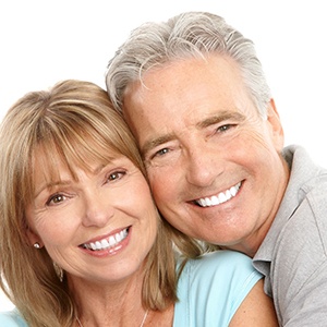 Smiling mature couple, glad they could afford dentures