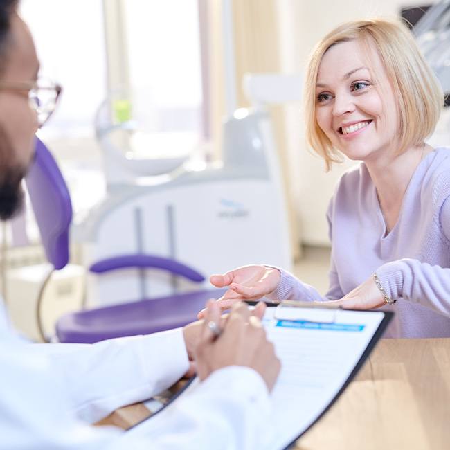 Woman talking to dentist about dental insurance forms