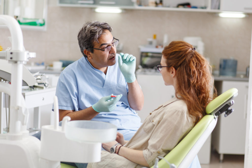 person speaking with dentist about All-on-4 dental implants in Van Nuys